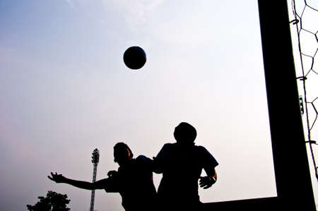 silhouette of football player heading for goalの写真素材
