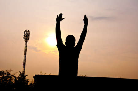 silhouette of man happy and victory in stadiumの写真素材