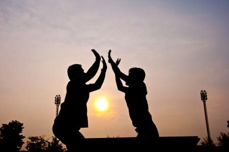silhouette of man jumping for victory and successの写真素材