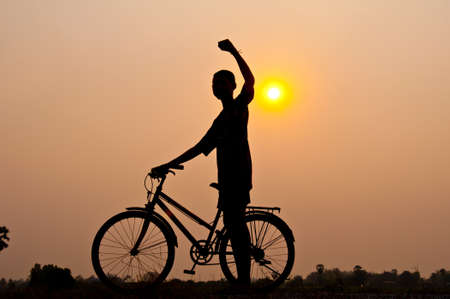silhouette of boy happy with bicycleの写真素材