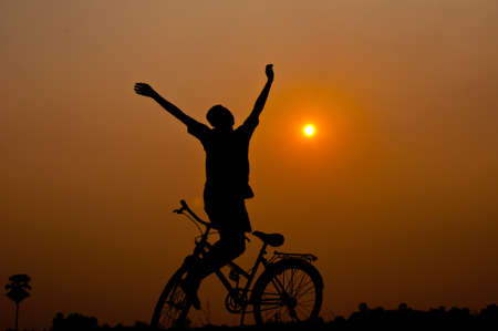 silhouette of boy happy with bicycleの写真素材