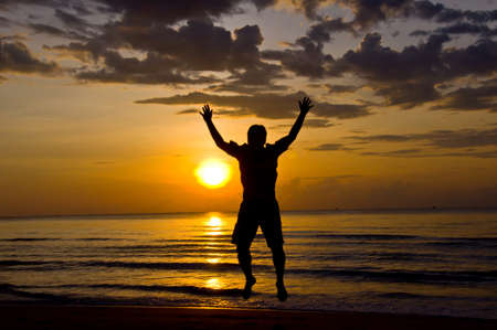 silhouette of man feel free and happy on the beachの写真素材