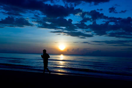 silhouette of man running on the beachの写真素材