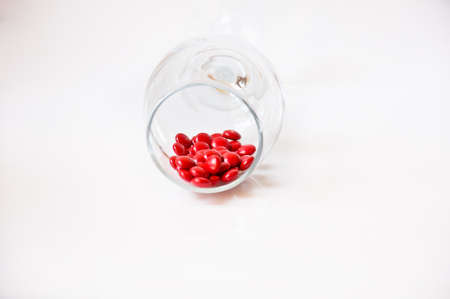 red pill in glass on white の写真素材
