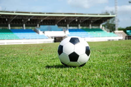 close up of black and white soccer on field with stadium backgroundの写真素材
