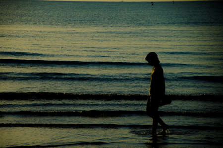 silhouette of woman walking  on the beachの写真素材