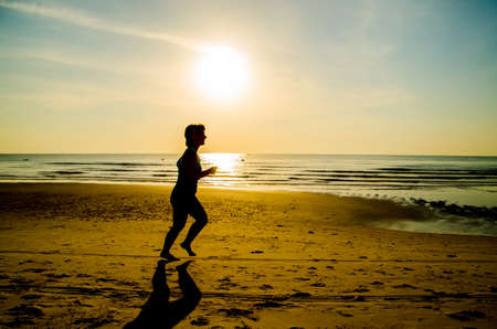 silhouette of woman running   on the beachの写真素材