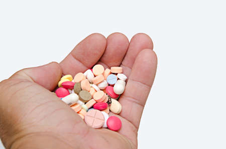 colorful of medicine in hand for treatment  on white backgroundの写真素材
