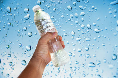 hand for bottle of water on drop water background