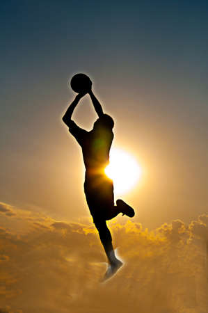 silhouette of goalkeeper jumping for catch the ballの写真素材