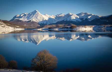 Winter card with mountains reflects in the lakeの写真素材