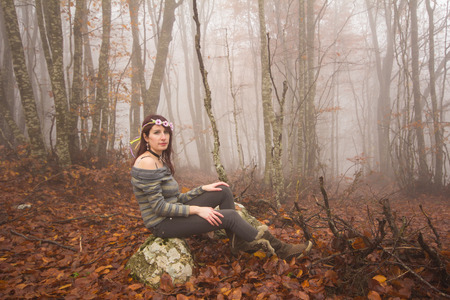 Smiling woman with walking sticks in a forest, having a breakの写真素材
