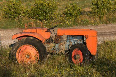 Old red rusty tractor in a fieldの写真素材