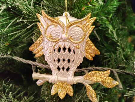 Photo of golden and white owl decoration on christmas treeの写真素材