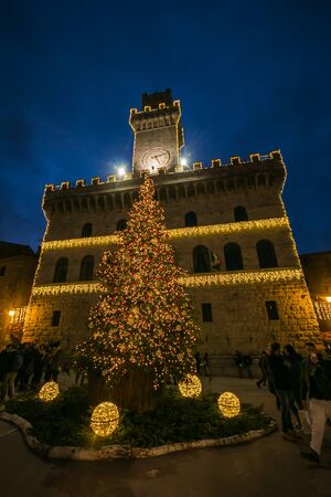 Tourists in the beautiful square of Montepulciano with giant Christmas tree and lights, Tuscanyの写真素材