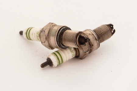 Used Spark Plug Set on White Background â€“ Old Car Engine Ignition Parts