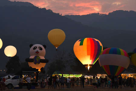 CHIANG MAI %u2013 MARCH 2, 2018 : Hot Air Balloon festival and people walking around with mountain on background in the evening day at Chiang Mai, Thailand.のeditorial素材