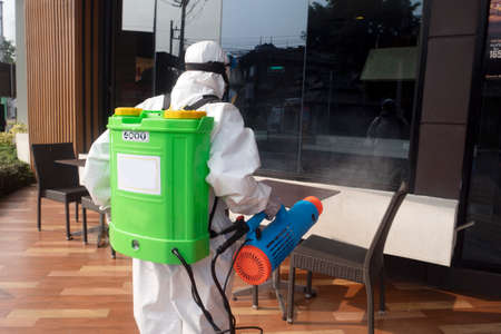 CHIANGMAI, THAILAND-APRIL 30, 2022 : Staff PPE uniforms suit are using an alcohol sprayer to clean the coronavirus in the street. Chiang Mai , Thailand.のeditorial素材