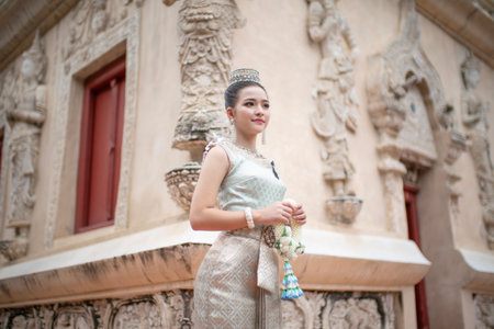 Beautiful young Asian woman in traditional Thai Dusit dress in an old temple in Chiang Mai, Thailand.の写真素材