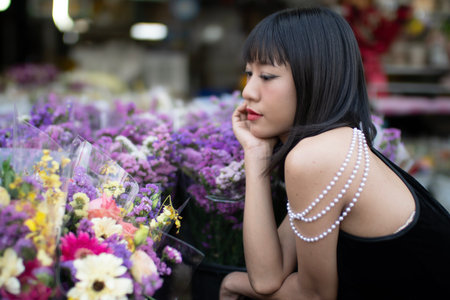 Young women from ASEAN countries stand in front of a shrine in Kad Luang Market, Chiang Mai Province.の写真素材