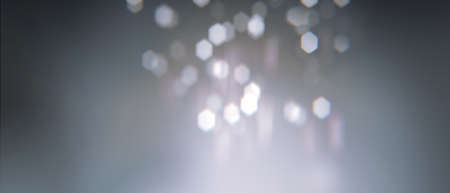 Realistic bokeh with geometric hexagonal iris. Soft  slightly pink abstract background with light particles out of focus. Long horizontal format.の写真素材