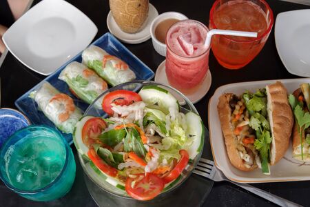 vietnamese salad , banh mi and fresh roll on the table