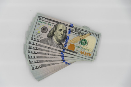 a stack of us 100 dollars cash with white backgroundの写真素材