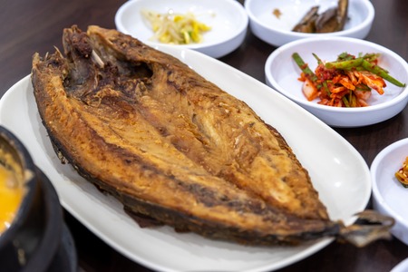 Korean style Grilled mackerel with side dish on the tableの写真素材