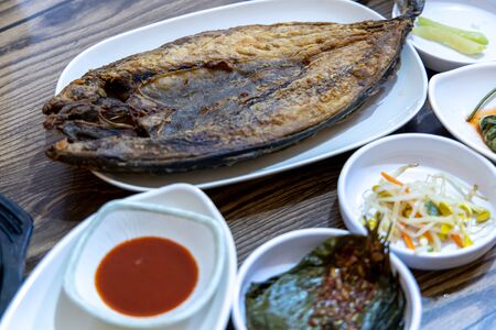 Korean food - Grilled mackerel with side dishes on the table