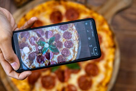 Pepperoni pizza with mobile phone, Philippines