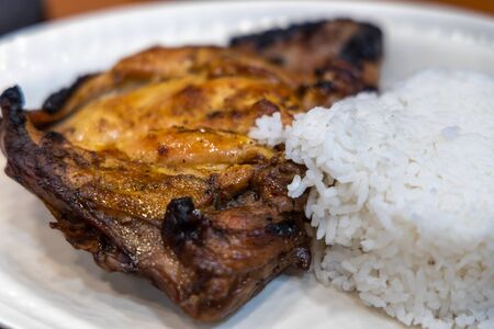 grilled chicken with rice and salad on the plateの写真素材