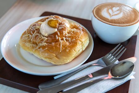 Filipino traditional desert Ensaymada with cafe latte, Philippines
