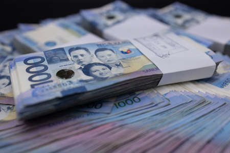 A pile of one thousand Philippines banknotes. Cash of Thousand dollar bills, Peso background image.の写真素材