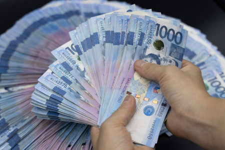 A pile of one thousand Philippines banknotes. Cash of Thousand peso bills, Peso background image.の写真素材