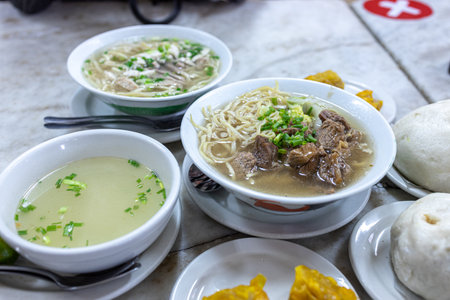 Popular Traditional Filipino Food Mai noodle soup with beef in a bowl on table