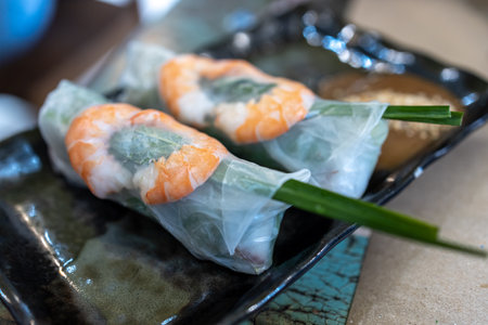 Fresh shrimp wrapped in rice paper and served with soy sauce on plate