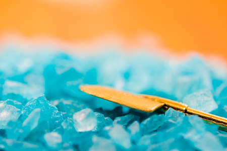 A shovel  photographed onto the heap of blue bath saltの写真素材