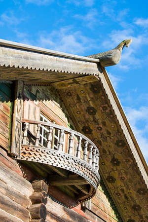 Wooden horse on the roof of traditional Russian cottage, painted Russian wooden architecture at the north of Russiaの写真素材