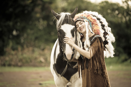 Cowgirl show love to horses on during sunset. Vintage tone.の写真素材
