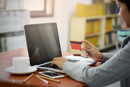 Asian business women pay for purchases using credit cards. During a laptop computer in the office.
Finance, Banking and Technology Concepts.の写真素材