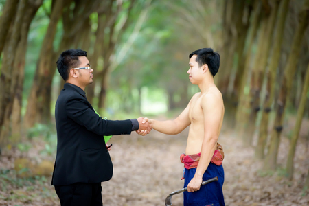 Business deal with Businessmen join hands with vegetable plant researchers in rubber plantation deal.の写真素材