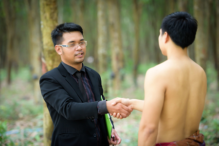 Business deal with Businessmen join hands with vegetable plant researchers in rubber plantation deal.の写真素材