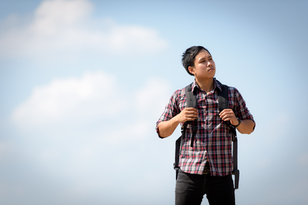 An Asian tourist man carrying a backpack enjoying a river. Holidays and nature concepts.の写真素材
