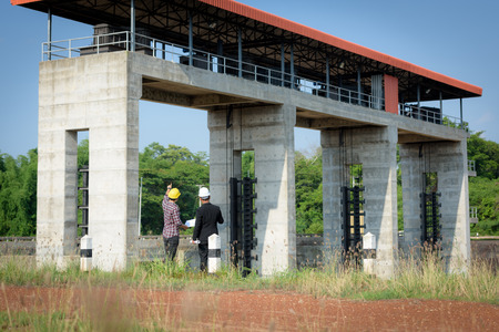Business men meeting with Engineers and supervisors are standing reading the blueprints at the construction site.の写真素材