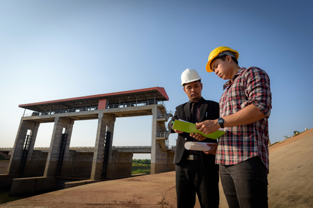 Business men meeting with Engineers and foremen are standing reading reports on construction sites.の写真素材