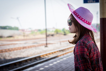 Girl tourist sitting on a bench in a train station.の写真素材