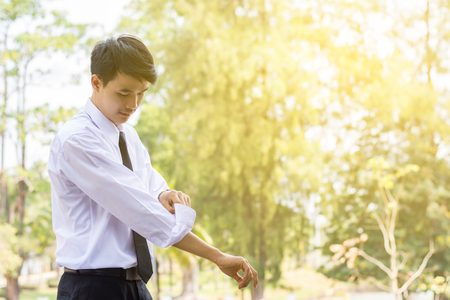 A young businessman is folding a white sleeve on his balcony.の写真素材