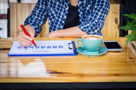 Woman sitting reading report in the coffee shop.の写真素材