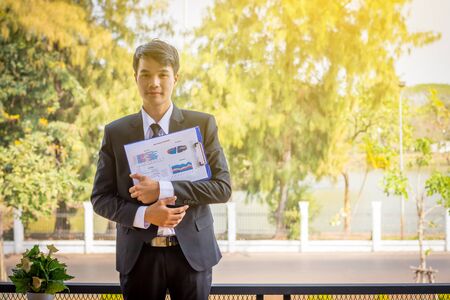 Finger of business man hold the paper report.の写真素材