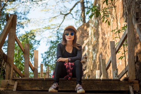 Tourist young woman wearing hat enjoying sitting on the stairs mountain.の写真素材